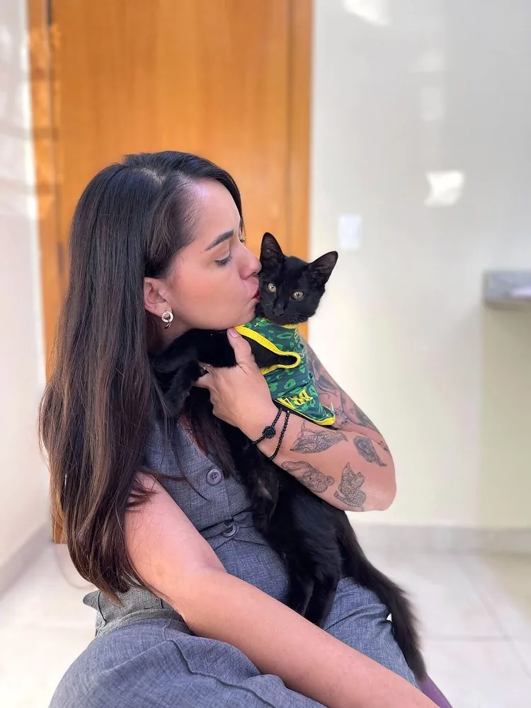 Profissional da Zenvet dando carinho em um filhote de gato preto